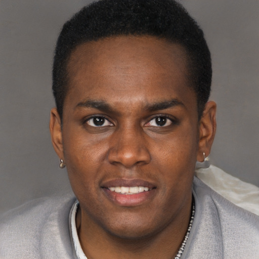 Joyful black young-adult male with short  brown hair and brown eyes