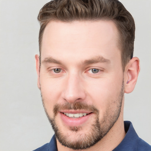 Joyful white young-adult male with short  brown hair and grey eyes