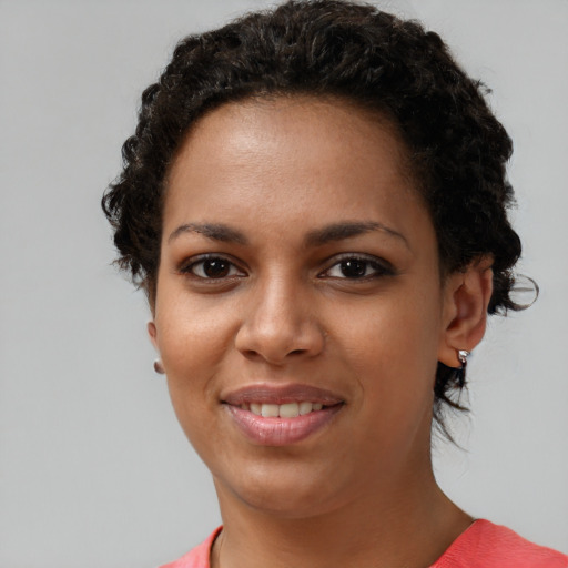 Joyful black young-adult female with short  brown hair and brown eyes