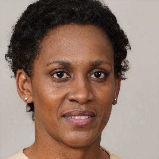Joyful black adult female with short  brown hair and brown eyes