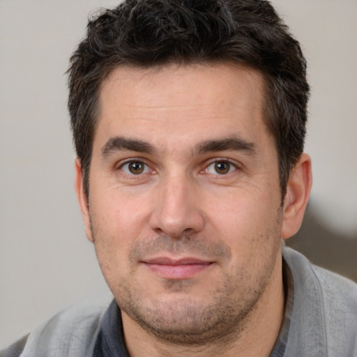 Joyful white adult male with short  brown hair and brown eyes