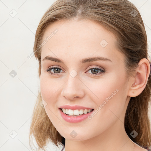 Joyful white young-adult female with long  brown hair and blue eyes