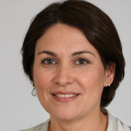 Joyful white adult female with medium  brown hair and grey eyes