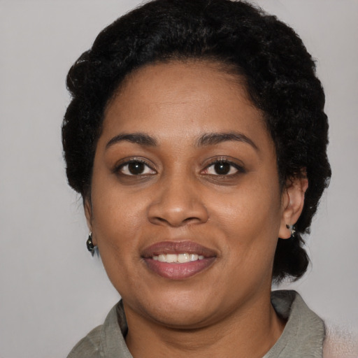 Joyful black young-adult female with short  black hair and brown eyes