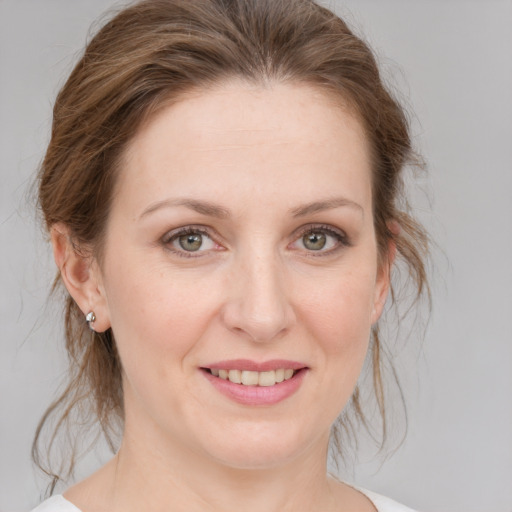 Joyful white young-adult female with medium  brown hair and grey eyes