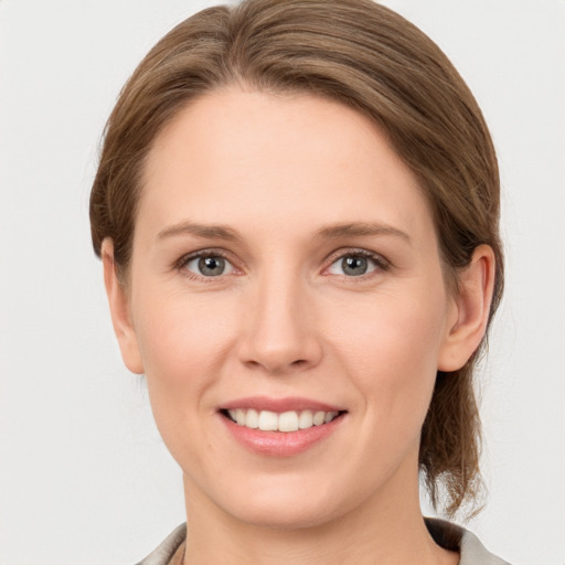 Joyful white young-adult female with medium  brown hair and grey eyes