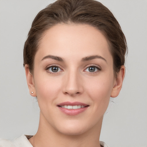 Joyful white young-adult female with short  brown hair and grey eyes