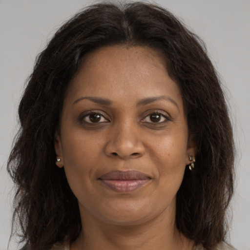 Joyful black adult female with long  brown hair and brown eyes