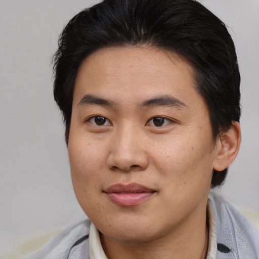 Joyful asian young-adult male with short  brown hair and brown eyes