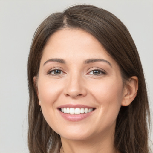 Joyful white young-adult female with long  brown hair and brown eyes