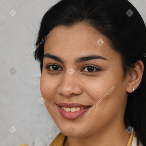 Joyful latino young-adult female with medium  brown hair and brown eyes