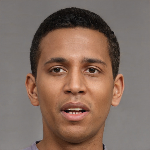 Joyful latino young-adult male with short  brown hair and brown eyes