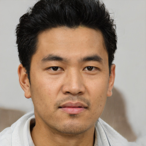 Joyful asian young-adult male with short  black hair and brown eyes