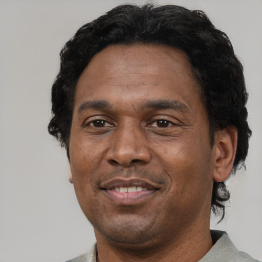 Joyful black adult male with short  black hair and brown eyes