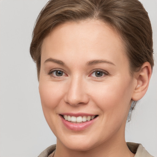 Joyful white young-adult female with short  brown hair and grey eyes