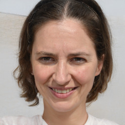 Joyful white adult female with medium  brown hair and blue eyes