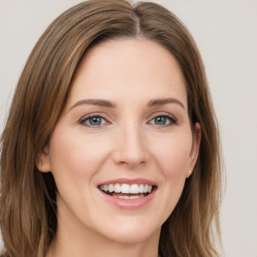 Joyful white young-adult female with long  brown hair and grey eyes