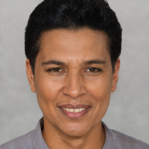 Joyful latino adult male with short  black hair and brown eyes