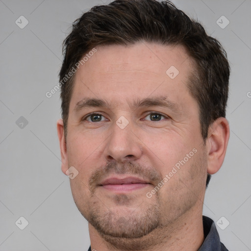 Joyful white adult male with short  brown hair and grey eyes