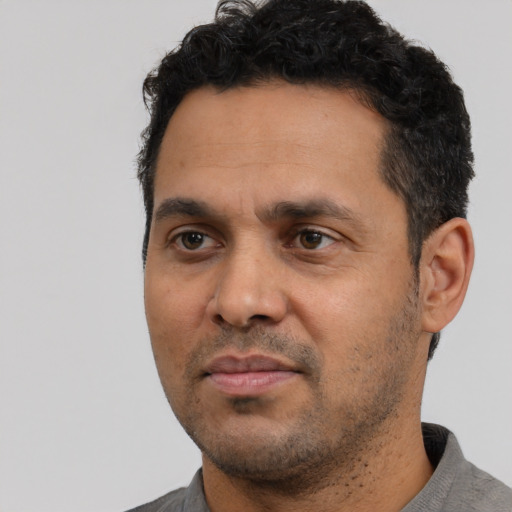 Neutral latino adult male with short  black hair and brown eyes