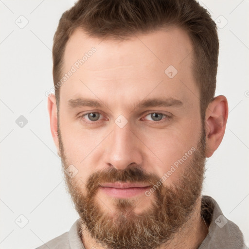 Joyful white young-adult male with short  brown hair and grey eyes