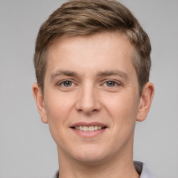 Joyful white young-adult male with short  brown hair and grey eyes