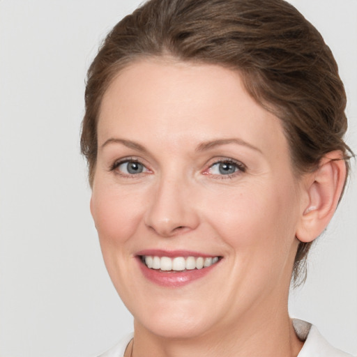 Joyful white adult female with medium  brown hair and grey eyes