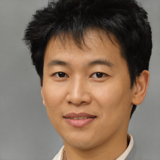 Joyful asian young-adult male with short  brown hair and brown eyes