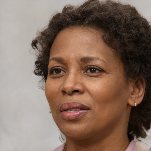 Joyful black adult female with medium  brown hair and brown eyes