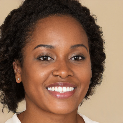 Joyful black young-adult female with medium  brown hair and brown eyes