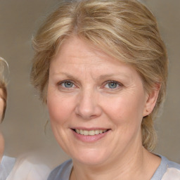 Joyful white adult female with medium  brown hair and blue eyes