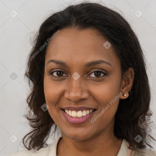 Joyful black young-adult female with long  brown hair and brown eyes