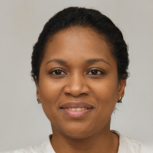 Joyful black young-adult female with short  brown hair and brown eyes