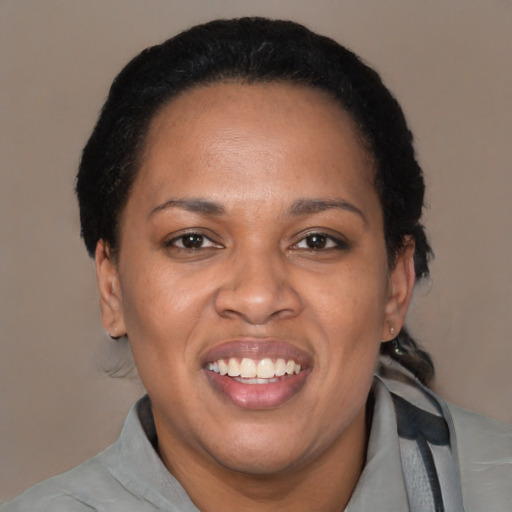 Joyful black adult female with short  black hair and brown eyes