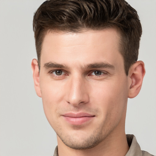 Joyful white young-adult male with short  brown hair and grey eyes