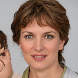 Joyful white adult female with medium  brown hair and blue eyes