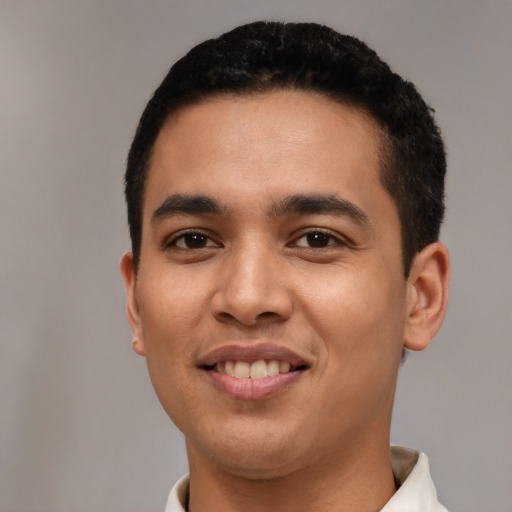 Joyful latino young-adult male with short  black hair and brown eyes