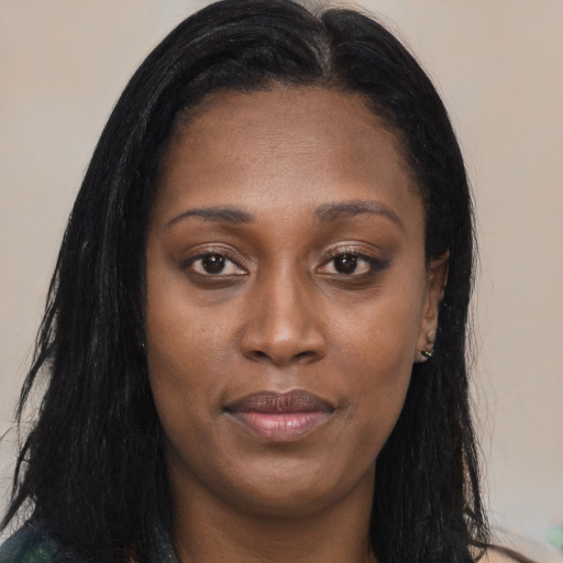 Joyful black young-adult female with long  brown hair and brown eyes