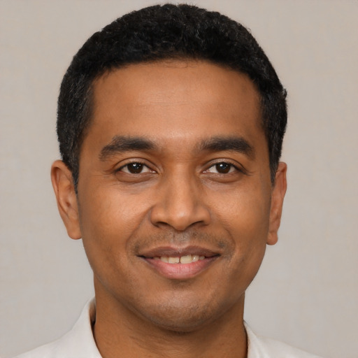 Joyful latino young-adult male with short  black hair and brown eyes