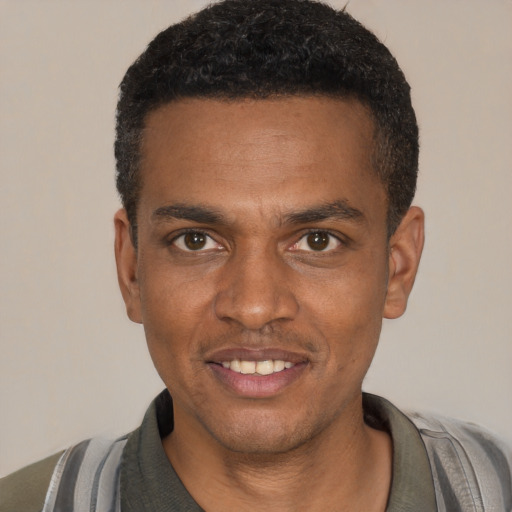 Joyful black young-adult male with short  black hair and brown eyes