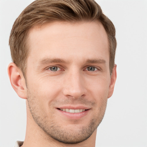 Joyful white young-adult male with short  brown hair and grey eyes