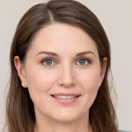 Joyful white young-adult female with long  brown hair and grey eyes