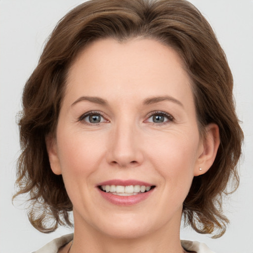 Joyful white adult female with medium  brown hair and grey eyes