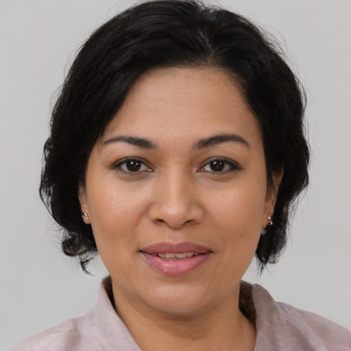 Joyful latino adult female with medium  brown hair and brown eyes