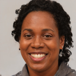 Joyful black adult female with long  brown hair and brown eyes