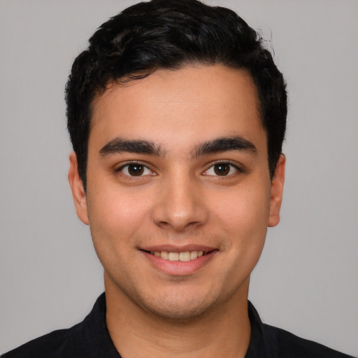 Joyful latino young-adult male with short  black hair and brown eyes