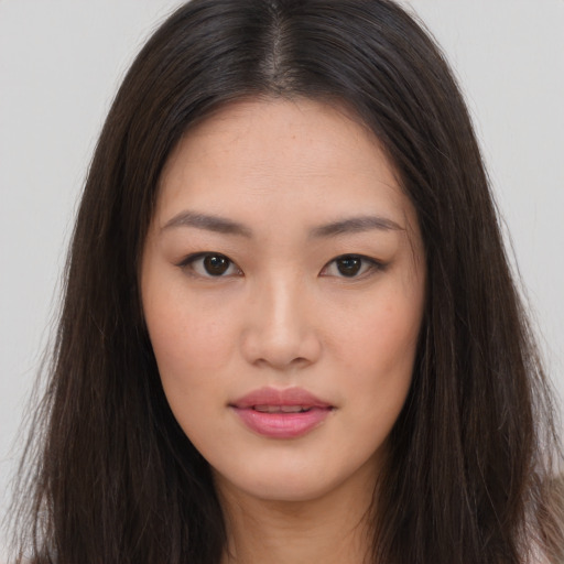 Joyful asian young-adult female with long  brown hair and brown eyes