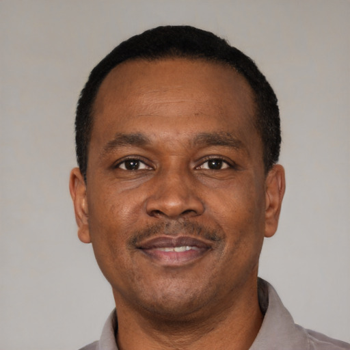 Joyful black adult male with short  brown hair and brown eyes