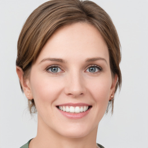 Joyful white young-adult female with medium  brown hair and green eyes