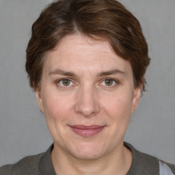 Joyful white adult female with medium  brown hair and grey eyes